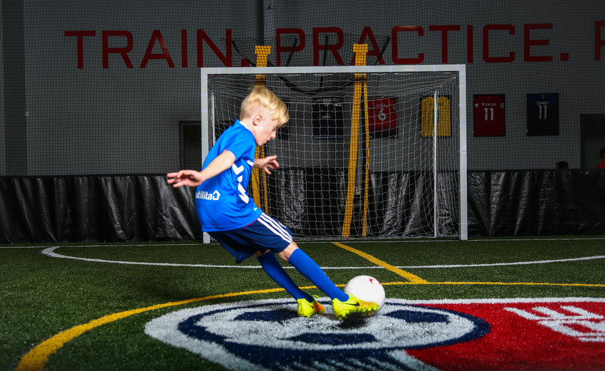 A young soccer player takes a shot in a practice at Pure Soccer Katy.