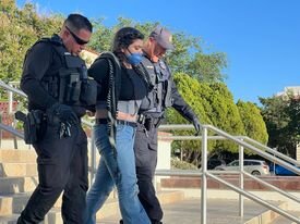 Police escort a protester who was taken into custody at NMSU’s Hadley administration building on May 9, 2024.