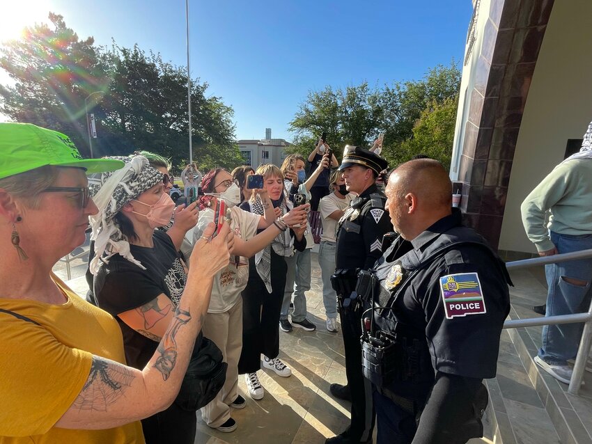 Supporters of the Palestine solidarity group’s sit-in at New Mexico State University face police officers outside the Hadley administration building on May 9, 2024.