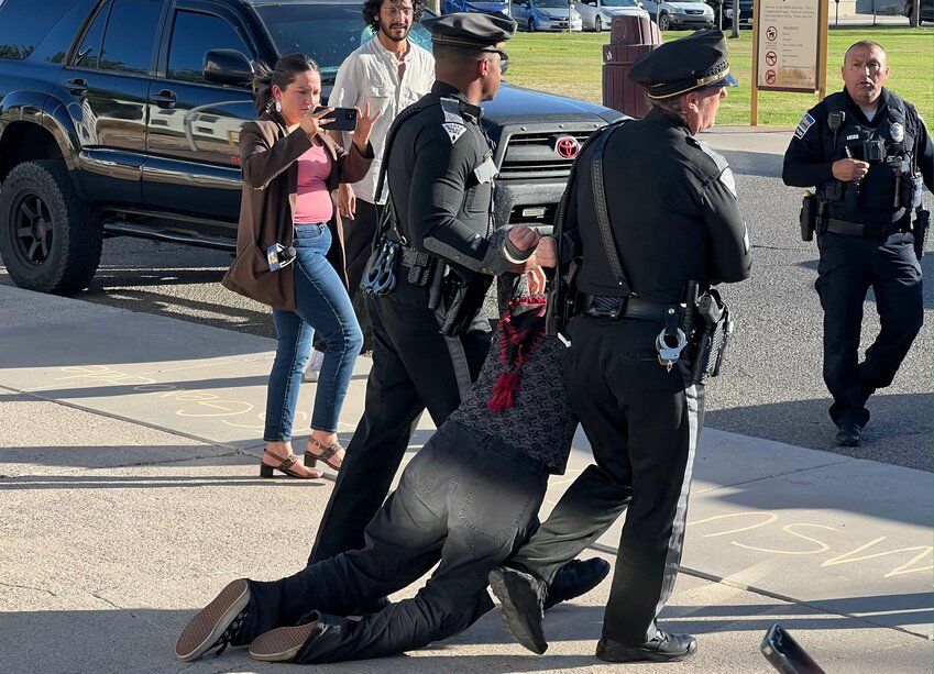 New Mexico State Police officers drag a protester from the Hadley administration building at New Mexico State University in Las Cruces on May 9, 2024.
