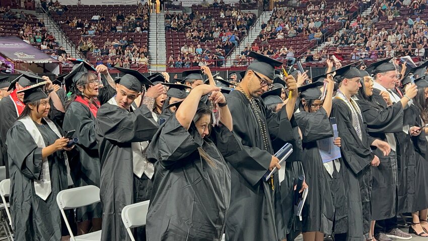 Doña Ana Community College students move the tassels on their graduation caps from right to left as their degrees are conferred during a graduation ceremony at the Pan-American Center in Las Cruces on May 9, 2024.