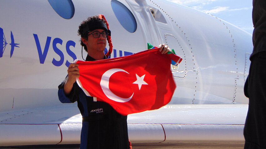Tuva Cihangir Atasever holding up the Turkish flag after his flight on the VSS Unity