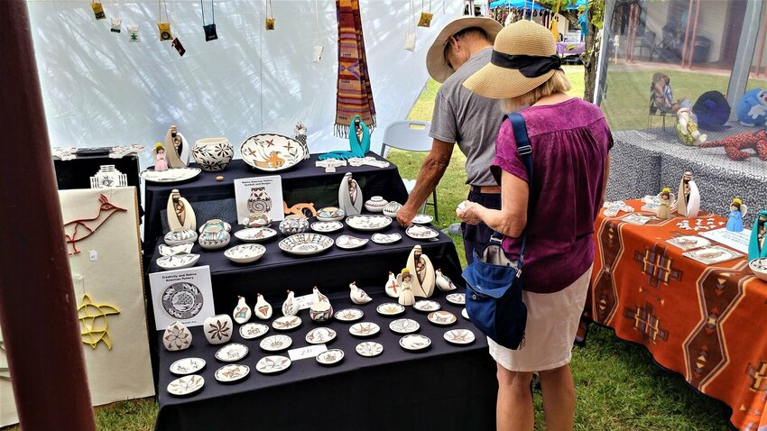 Couple walking through booths at the Franciscan Festival