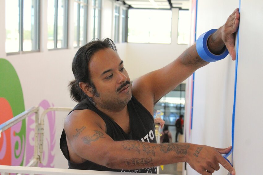 Carlos Morales-Silva applies painter’s tape as he prepares a wall for a mural at NMSU’s Museum of Art in Las Cruces on Sept. 23, 2024.