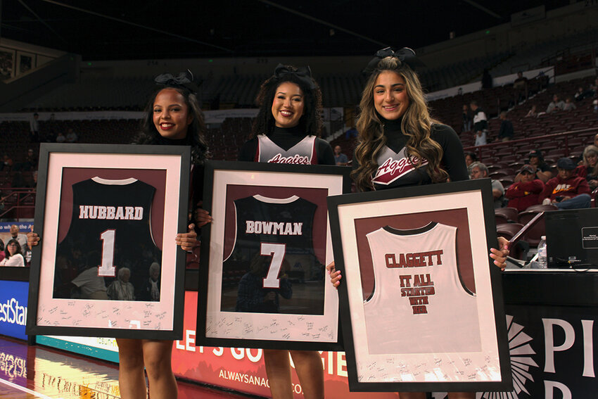 New Mexico State cheerleaders stand with jerseys gifted to Barbra Hubbard, Wanda Bowman and the Dickerson family at the NMSU women’s basketball game against Sam Houston State University. The half-time ceremony honored the three women who have been key to helping nurture the women’s athletics program at NMSU.