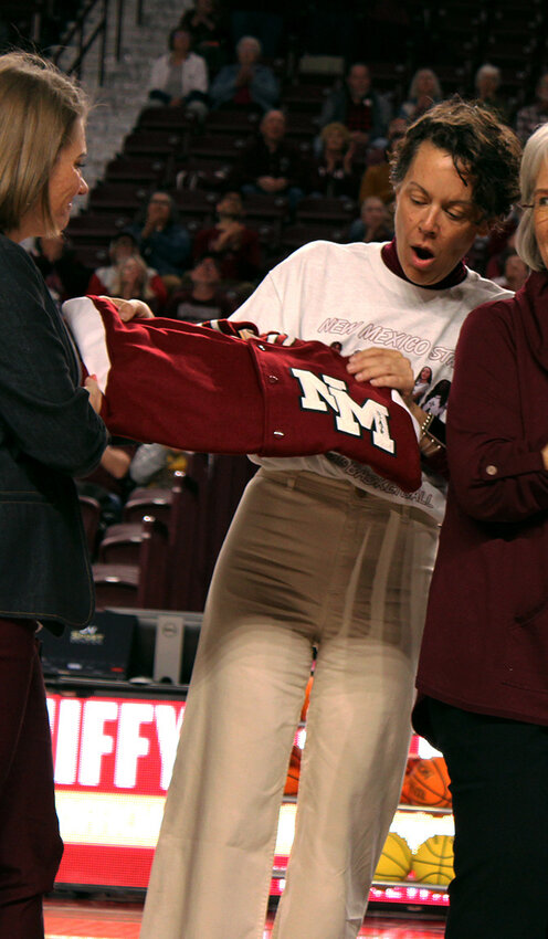 Amber Burdge presents Marci Dickerson and the Clagett family with a New Mexico State Letterman in Sybil Clagett’s honor. Clagett was Dickerson’s grandmother. Clagett was one of the first two women to letter in athletics at what was then New Mexico State College in the late 1930s