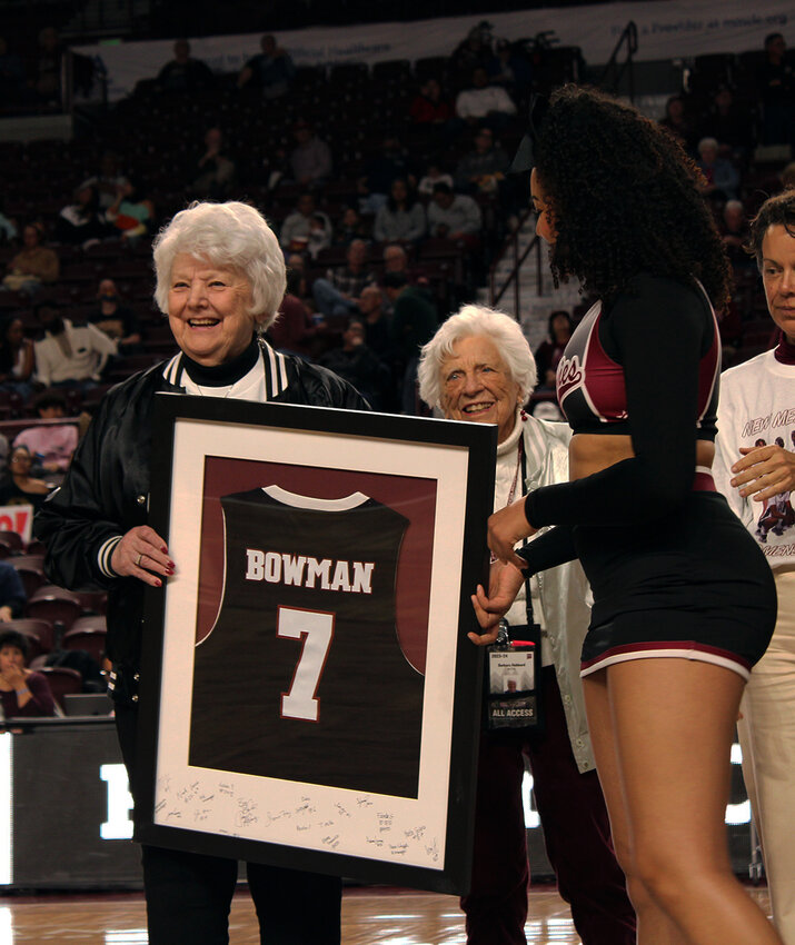 A New Mexico State cheerleader hands Wanda Bowman a jersey gifted by the New Mexico State Women’s basketball program during half-time at Saturday’s women’s basketball game between NMSU and Sam Houston State University. Las Cruces Bulletin photo by Jewel Dominguez