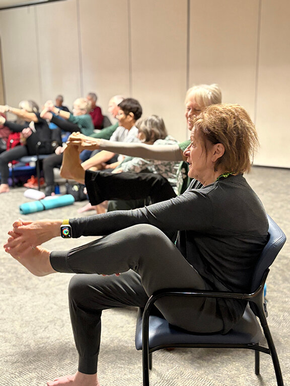 One patient stretches her toes to massage her feet during a new yoga move during a Monday yoga class.