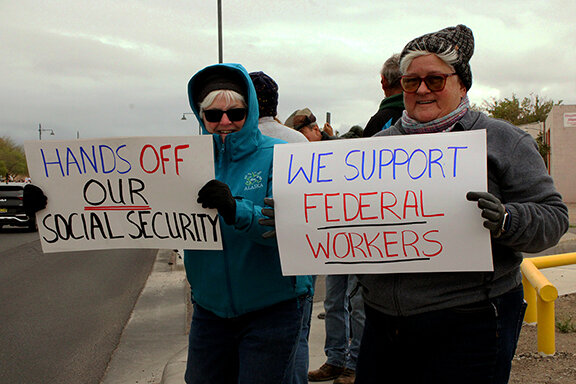 Mary and Linda McDermott stand with signs that read “Hands Off Our Social Security” and “We Support Federal Workers” across the street from Albert Johnson Park at the Hands Off! Protest, April 5, 2025. A nationwide protest to push back against President Trump’s recent executive orders and policy changes implemented by the Department of Government Efficiency.