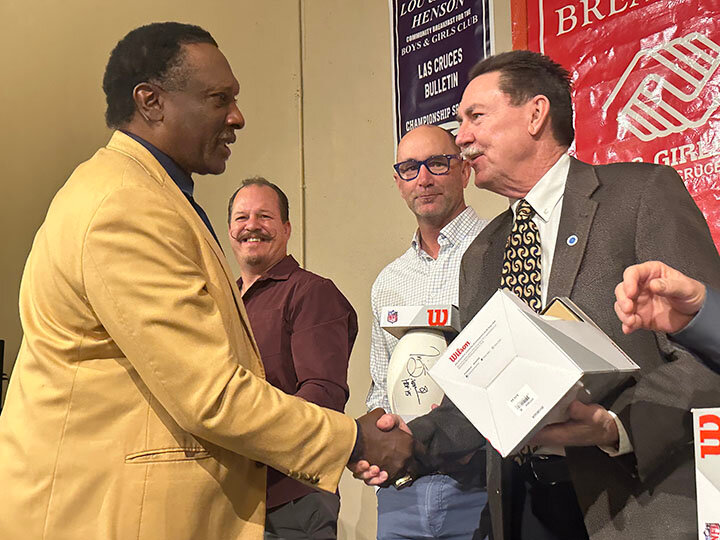 Tim Brown shakes hands with Boys and Girls Club Emeritus Director and District Judge James T. Martin after he makes another donation to the club.