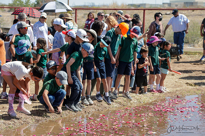 Children from Las Cruces Catholic School gather to watch the blessing of the field as the water flows in.