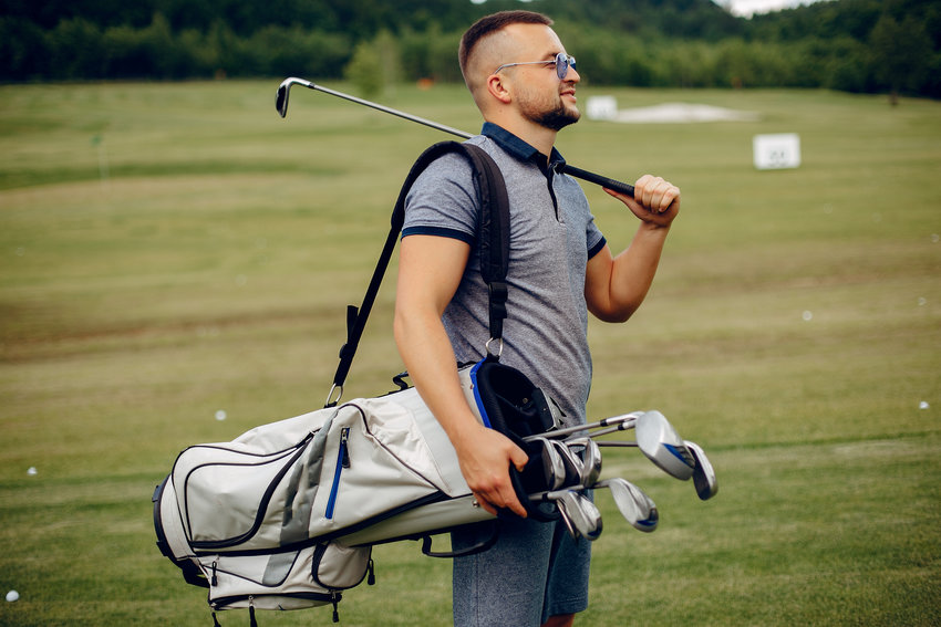Man in a golf course. Male in a sport clothes. Guy playing golf