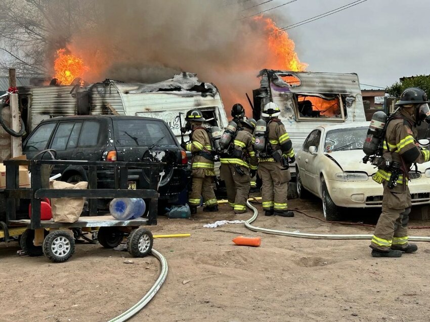 Las Cruces firefighters work a fire that damaged two travel trailers and endangered other buildings on McFie Avenue on Wednesday, March 6.