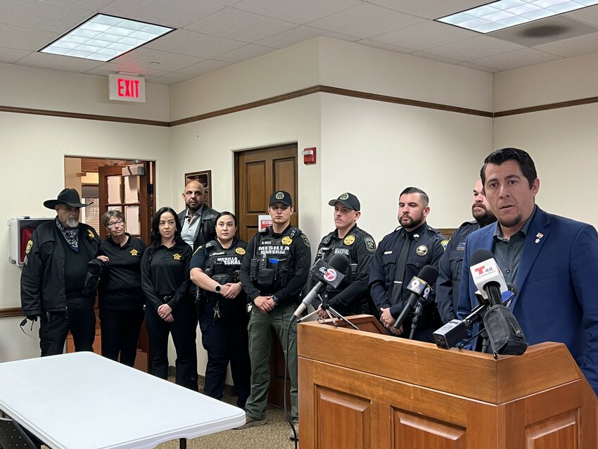 Mesilla Mayor Russell Hernandez, at podium, is flanked by Mesilla Marshals and Dona Ana County Sheriff officers and staff as he introduces a press conference on April 10, 2024. Sheriff Kim Stewart is second from the left.