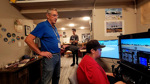 Bill Soules directs Dominic Orona as the student does a practice lap on the Redbird flight simulator.