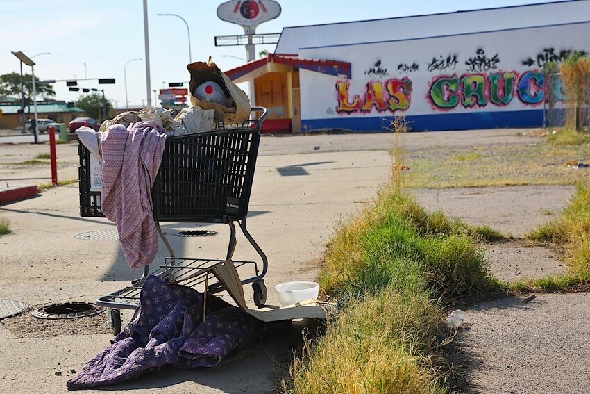 A shopping cart with somebody’s few belongings is seen in a vacant lot in Las Cruces on July 30, 2024.