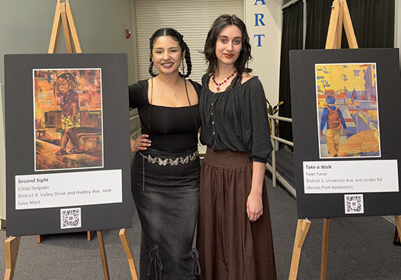 New Mexico State University art students Citlali Delgado (left) and Yalet Yanar stand next posters of their artwork that will adorn Las Cruces bus stops as part of a public art project called Art Stop 2025 sponsored by the City of Las Cruces.