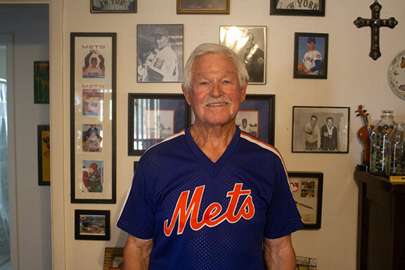 Jerry Hinsley in front of photos from his baseball years.