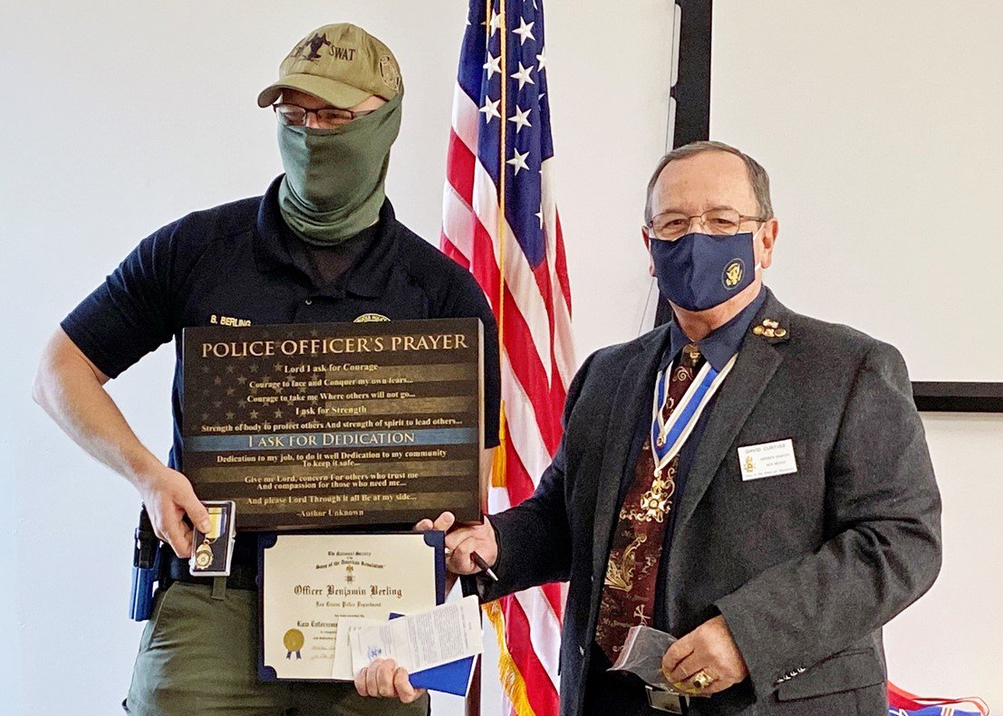 Past Gadsden Chapter President Dave Curtiss, right, presents a Sons of the American Revolution law enforcement commendation medal and a wooden plaque to Officer Benjamin Berling of the Las Cruces Police Department.