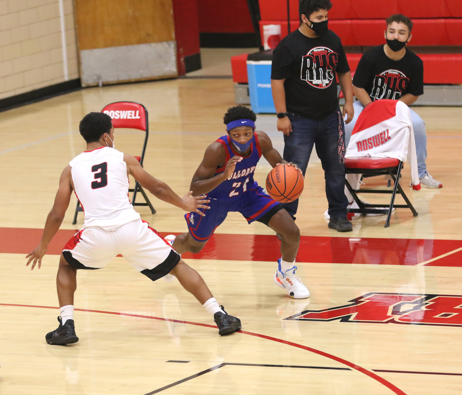 Las Cruces guard William "Deuce" Benjamin makes a move on Roswell defender Talon Sanders early in the first quarter of Thursday night's semifinal contest at the Coyote Den in Roswell.