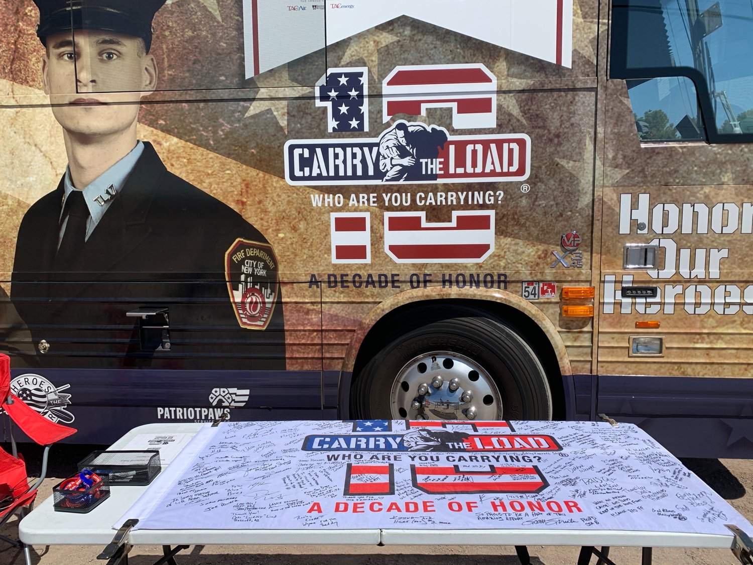 At an information station, a flag to be carried on the relay and the Carry the Load bus display the intent of the relay project to honor veterans and first responders who have lost their lives.