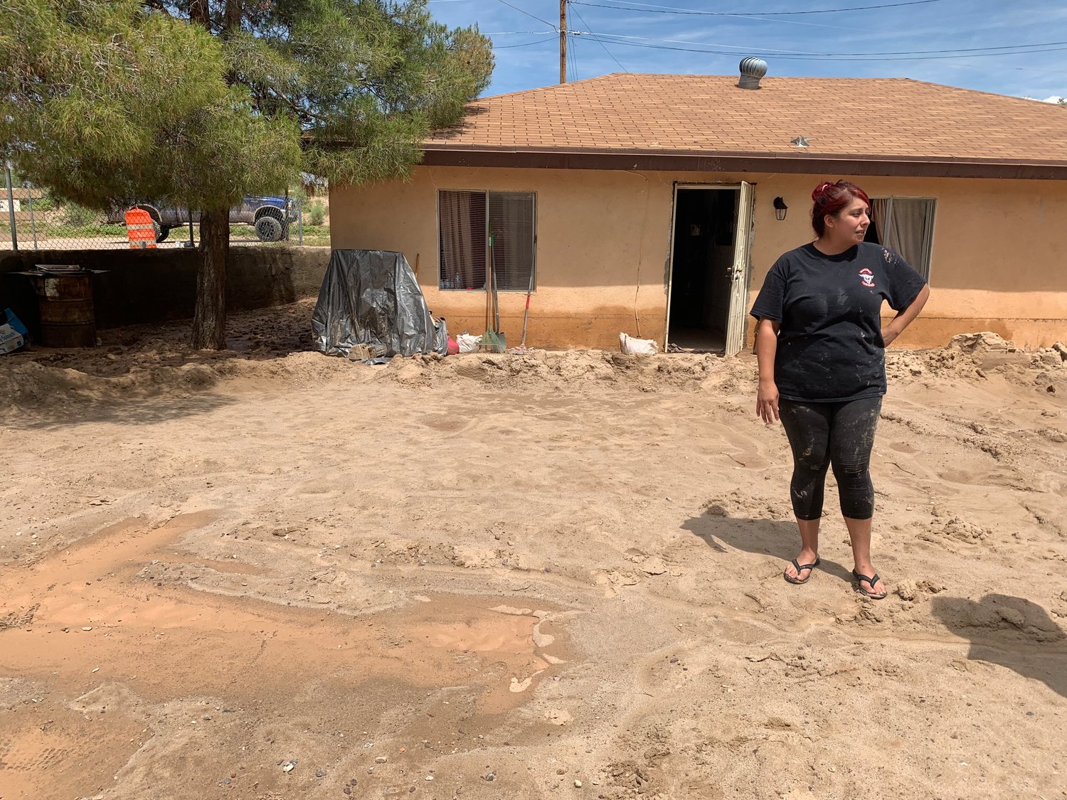 Clarissa Soto stands before the La Union home her father built 37 years earlier where she lives with her mother, daughter and two dogs. The family escaped the water flooding the house through a window.