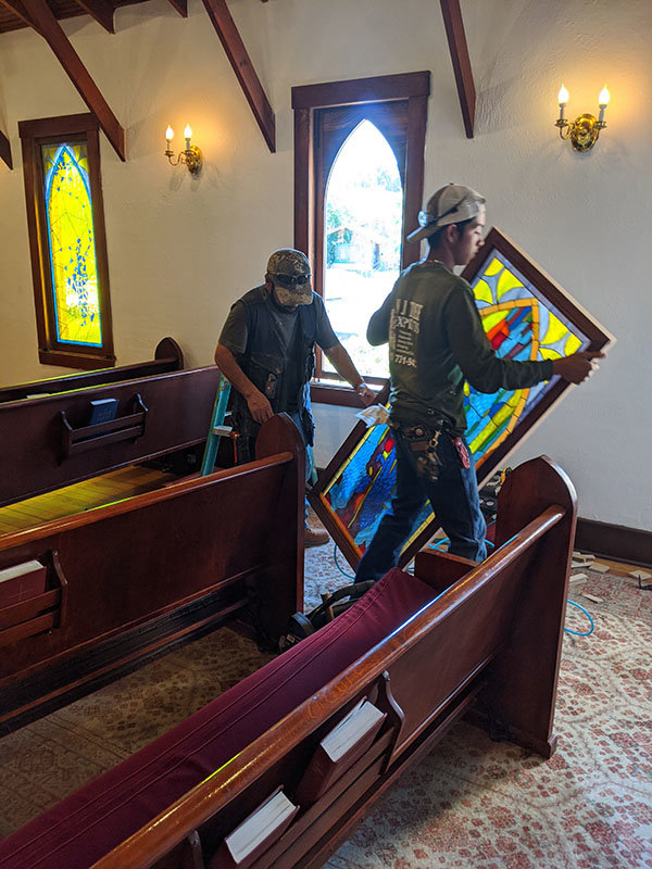Workers helped to install one of eight stainedglass windows at St. Andrew’s Episcopal Church chapel. The project was completed in mid-August.