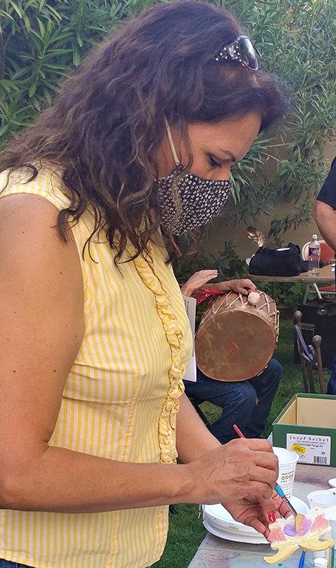 Doña Ana County Health and Human Services Department Program Administrator Anabel Canchola paints a ceramic wing at the Healing Wings reception Aug. 27 at Agave Artists’ Gallery in Mesilla.