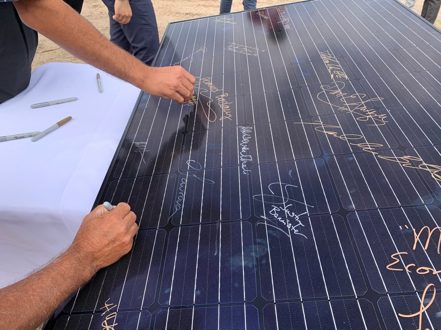Guests and officials attending the Sept. 23 opening of the  Aggie Power solar facility are invited to sign one of the panels to be installed.
