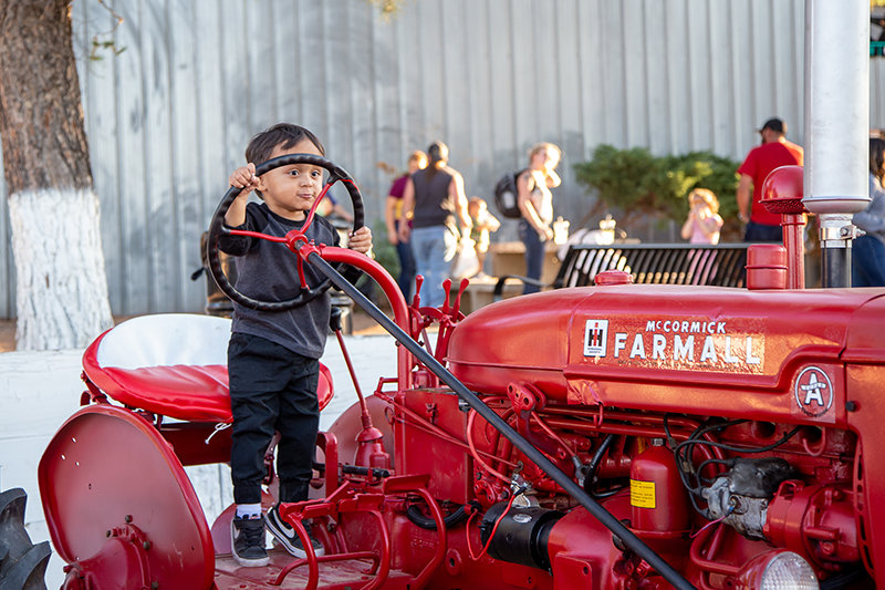 Myles Sorge, 2, pretends to be a farmer as he plays with a large tractor at the Southern New Mexico State Fair on Saturday, Oct. 2.