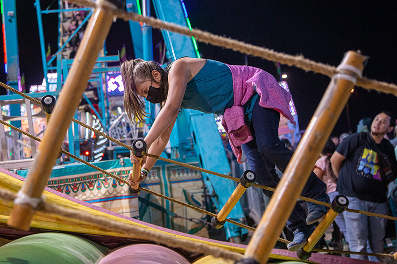 Alyssa McGuffin, 10, attempts to climb a wobbly ladder and ring the bell at the end Saturday night, Oct. 2, at the Southern New Mexico State Fair.