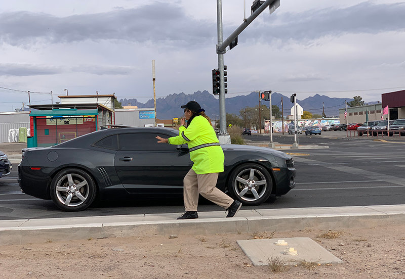 Working to manage fast traffic Marisela Padilla performs duties as crossing guard at the busy intersection at Valley Drive and Hadley Road where vehicles have a difficult time slowing down for the students walking home from MacArthur Elementary School.