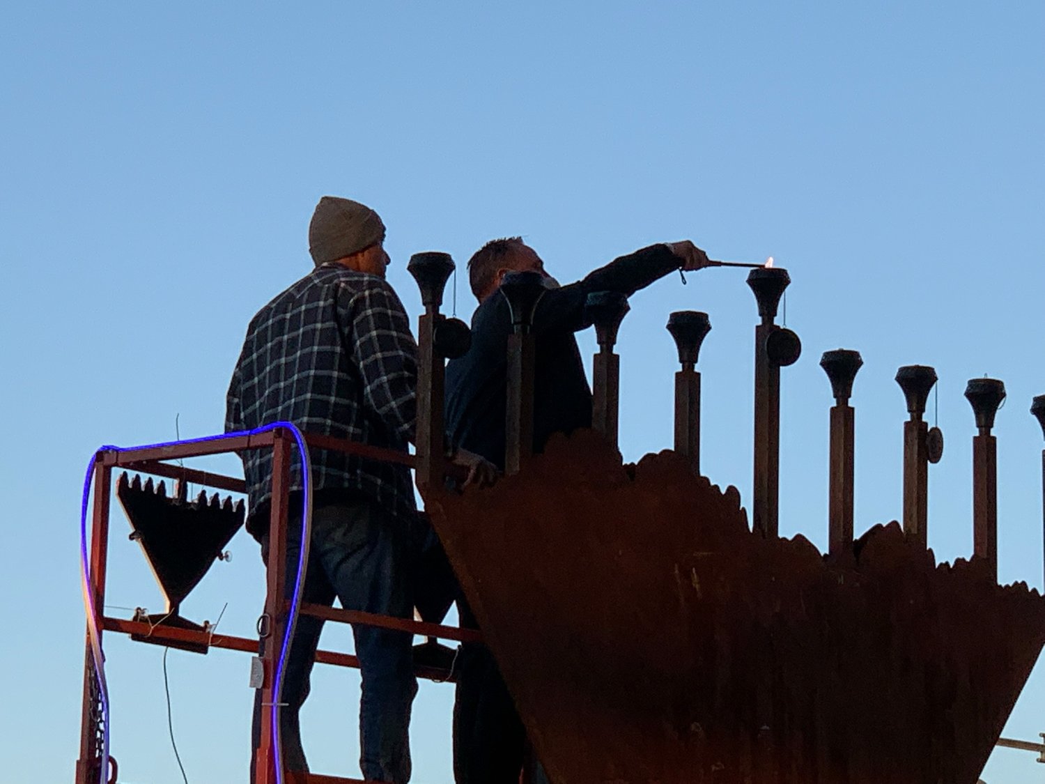 New Mexico Lt. Gov. Howie Morales, right, lights the shammash (helper flame) on the giant menorah at Plaza de Las Cruces as the sun sets Sunday, Nov. 28. Ross Marks is on the left and will light the first flame of the season. Chanukah begins at sunset and continues for eight days. This year’s celebration on the plaza welcomed and fed close to 1,000 people.