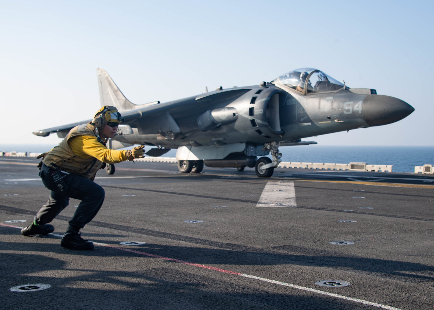 Aviation Boatswain’s Mate 3rd Class Alysa Sanchez, from Las Cruces, N.M., signals to an AV-8B Harrier attached to Marine Attack Squadron 214, 11th Marine Expeditionary Unit (MEU), as it takes off of the flight deck of the amphibious assault ship USS Essex (LHD 2), Jan. 4.