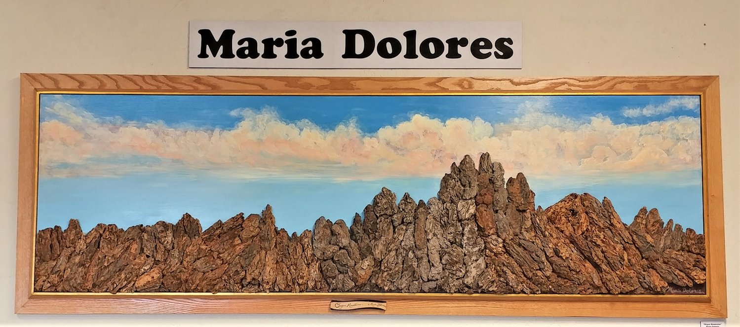 Maria Dolores’ depiction of the Organ Mountains in acrylic and wood chips is part of her February show at Frame and Art Center.