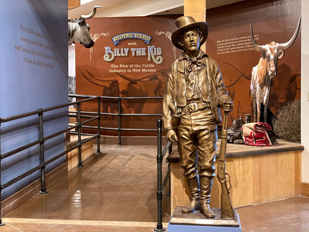 Billy the Kid, an oil on cast resin statue made by Las Cruces artist Bob Diven, welcomes visitors to the “Riding Herd” exhibit. Diven’s birthday, July 14 (1959), is the same day (1881) that Billy the Kid was shot and killed by Pat Garrett in Fort Sumner, New Mexico.