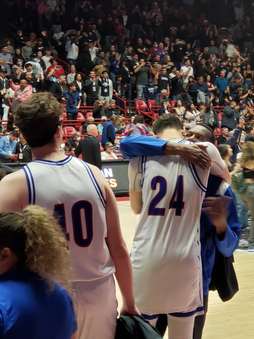 Isaiah Carr is hugged by coach William Benjamin after Las Cruces High loses to Volcano Vista in state 5A finals