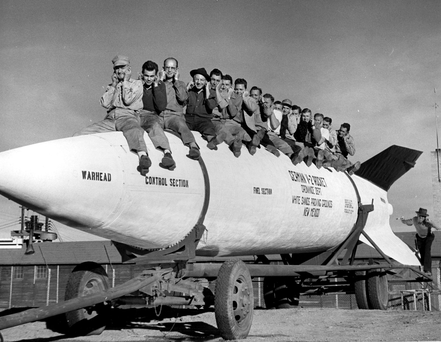 General Electric employees posing on a V-2 rocket at White Sands Proving Ground (now White Sands Missile Range) in New Mexico.