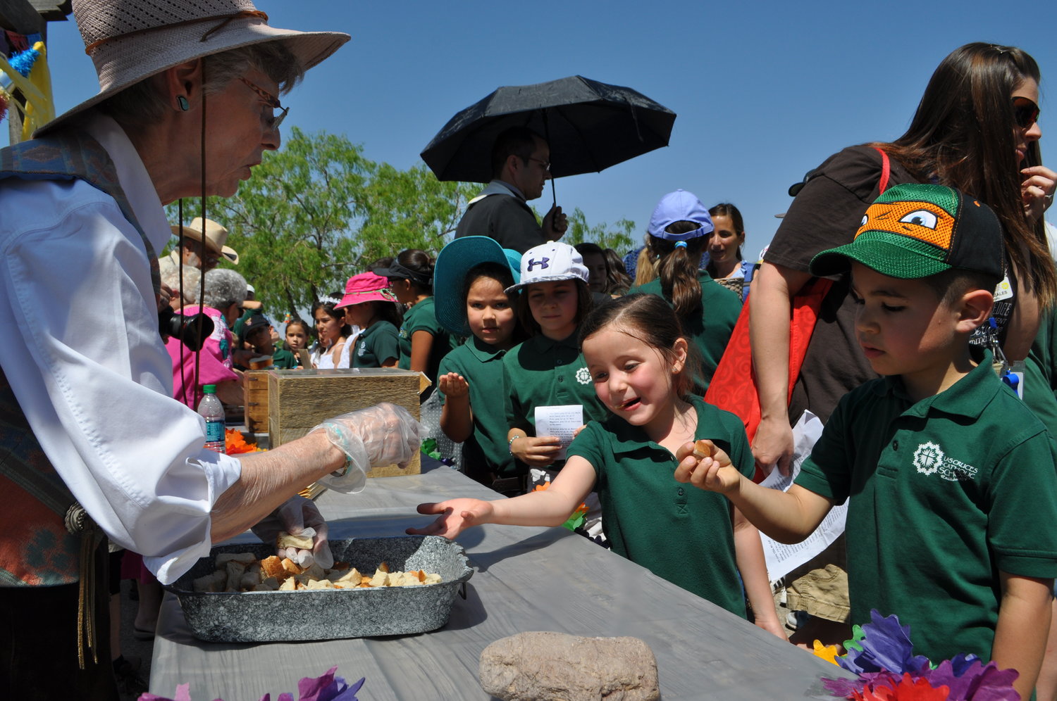 STudents get portions of blessed bread during a past Blessing of the Fields.