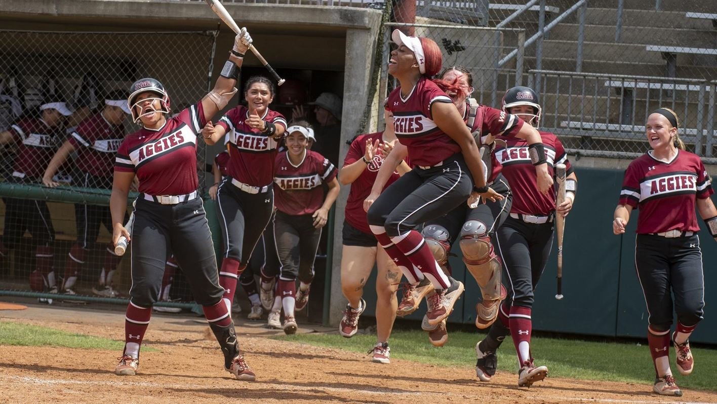 The New Mexico State University softball team celebrates its win in the first round of the WAC tournament May 11.