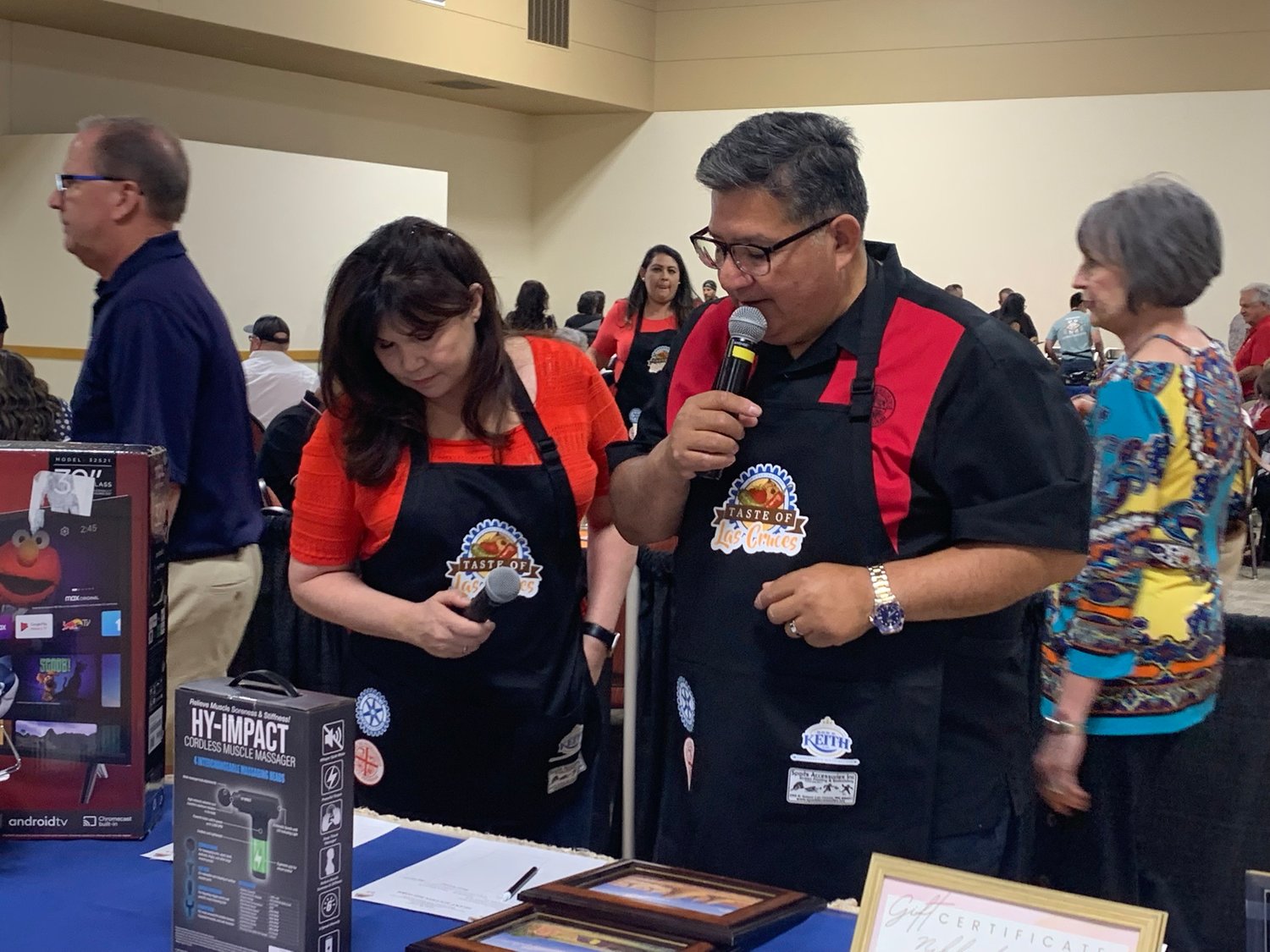 Stephanie Guadian of Electronic Caregiver and Lorenzo Alba with Casa de Peregrinos serve as emcees for the Taste of Las Cruces event as they talk about silent auction choices.