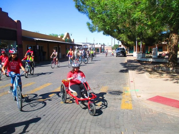 Participants of the first Every Body Rides with Grace Adaptive Cycle Parade ride, walk and roll thru the streets of Mesilla to celebrate adaptive cyclists.