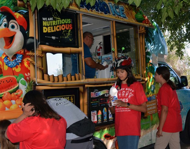 Keith Placencio serves up refreshing Kona Ice to attendees at the Every Body Rides with Grace Adaptive Cycle Parade.
