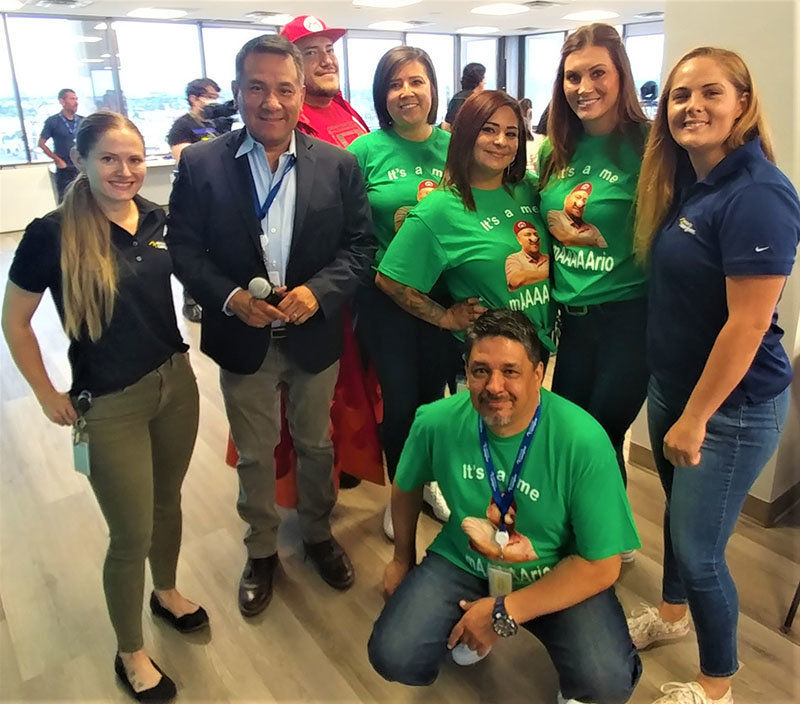At Electronic Caregiver’s first ever International Chess Tournament are, left to right, Alexia Severson, Executive Director John Muñoz, Mario Sauceda (in red), Gabriela Armijo, Jasmine Evans, Michelle Hernandez, Nicole Pond and Margarito Nuncio (kneeling in middle). They are all Electronic Caregiver employees. Those in the green shirts showed up to support Saucedo, who participated in the tournament.
