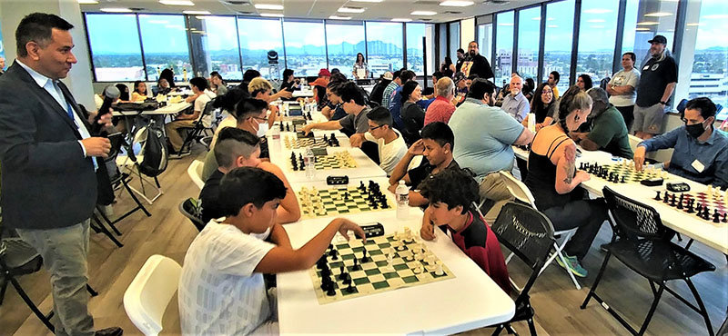 As tournament coordinator John Muñoz looks on, chess players compete in Electronic Caregiver’s first ever International Chess Tournament.