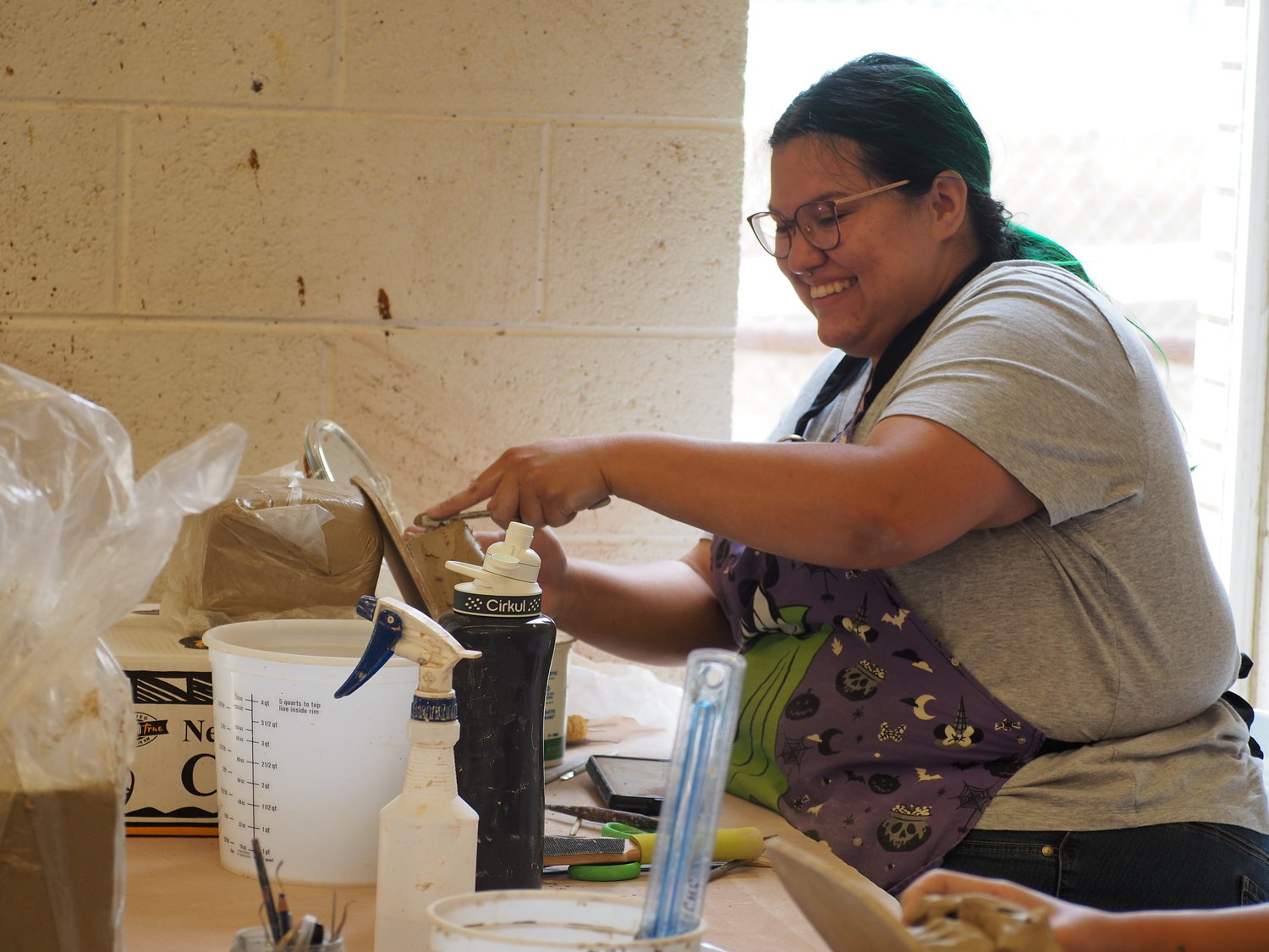 A workshop participant enjoys her clay project in the Western New Mexico University clay area.