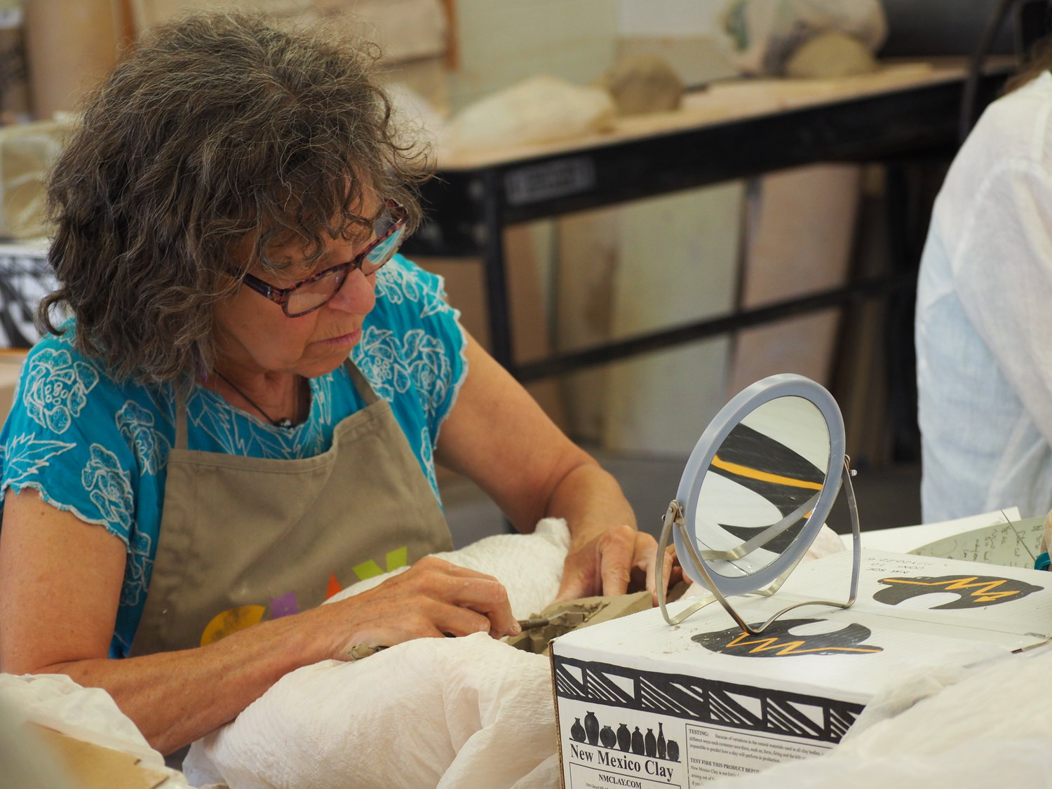 Zoe Wolfe carefully crafts her idea in the clay through the delicate stroke of her skillful hand.