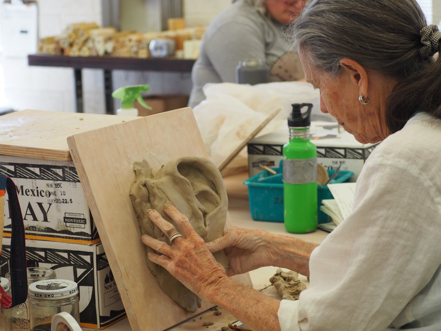 A workshop participant details her clay ear as she gets ready to begin crafting a full head sculpture during her project at Western New Mexico University
