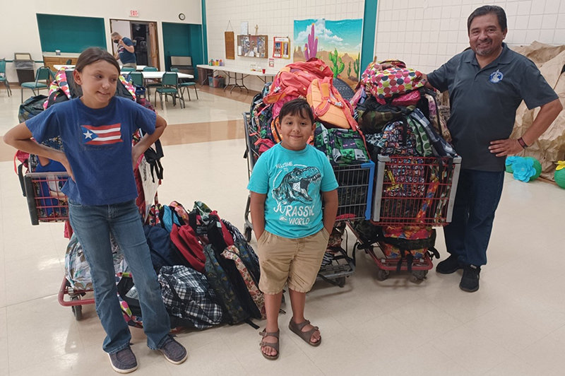 Backpack donations. Every year St. Paul’s United Methodist Church provides filled backpacks for Central Elementary School. “This year we delivered 153 backpacks to our kids,” said church member Diane Schutz. Central Elementary students are shown here with the school’s P.E. teacher, Tommy Esparza.