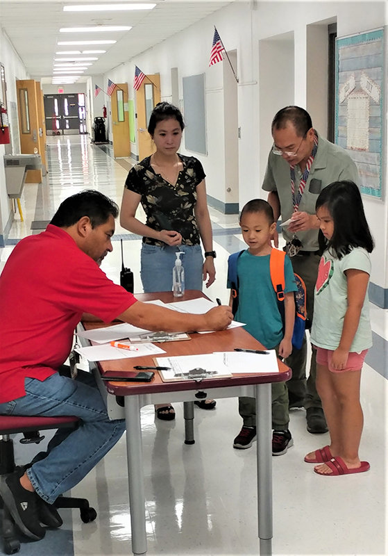 Students and parents sign in for the first day of the 2022-23 school year at Central Elementary School, 150 E. Alameda Blvd. Assisting with the signing in is Central Elementary P.E. teacher Tommy Esparza, in his 33rd year with Las Cruces Public Schools.
